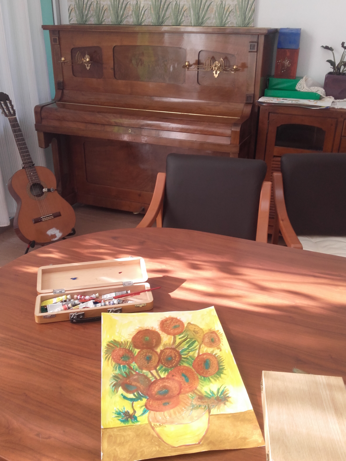 Composición de piano, guitarra y cuadro sobre mesa